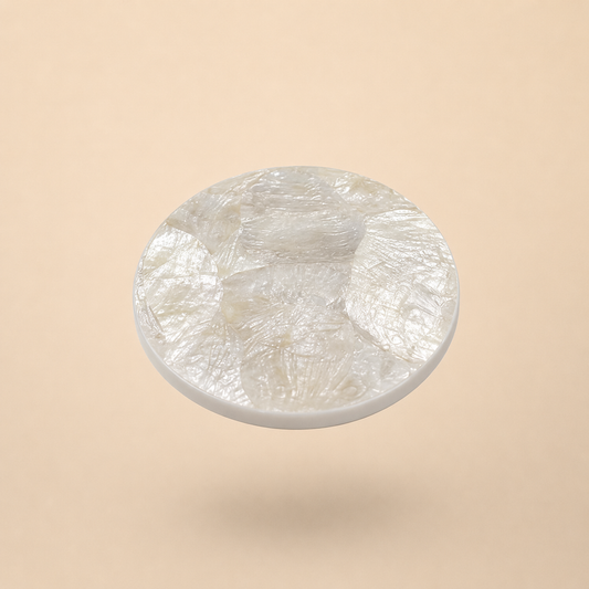 Round mother of pearl coaster on beige background