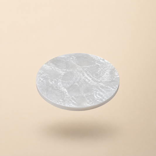 Round mother of pearl coaster on a beige background